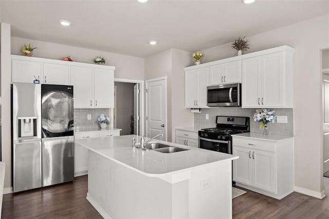 kitchen with stainless steel appliances, a kitchen island with sink, sink, and white cabinets