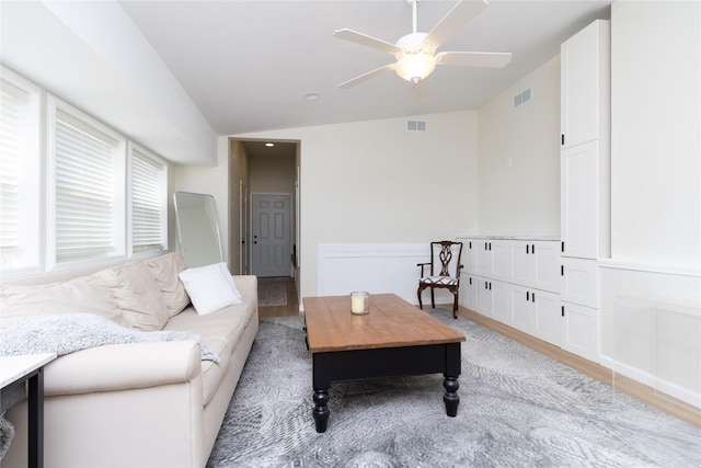 living room with vaulted ceiling, ceiling fan, and light wood-type flooring