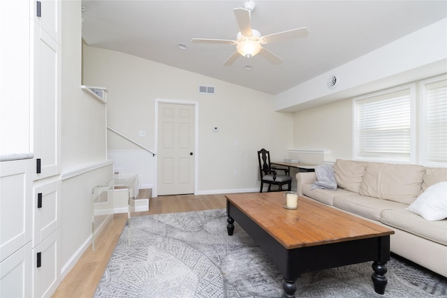 living room with lofted ceiling, ceiling fan, and light hardwood / wood-style flooring