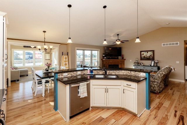 kitchen with stainless steel dishwasher, decorative light fixtures, sink, and white cabinets