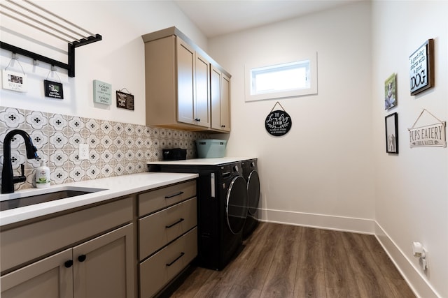 clothes washing area with dark hardwood / wood-style flooring, sink, cabinets, and independent washer and dryer