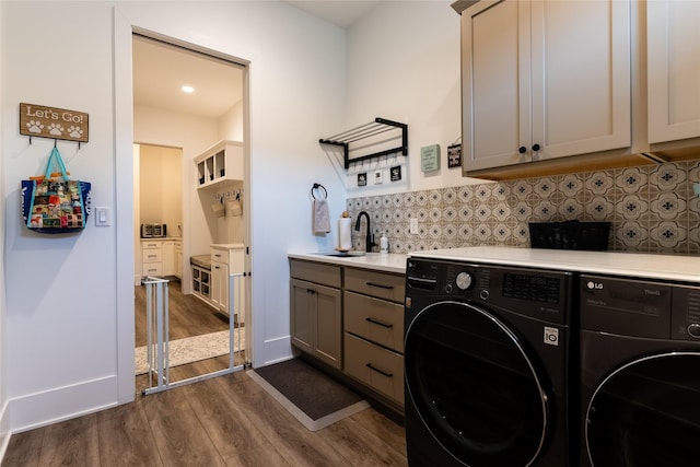 laundry room with dark wood-type flooring, cabinets, sink, and washer and dryer