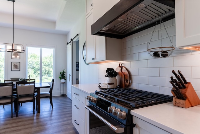 kitchen featuring premium range hood, a barn door, gas range, and white cabinets