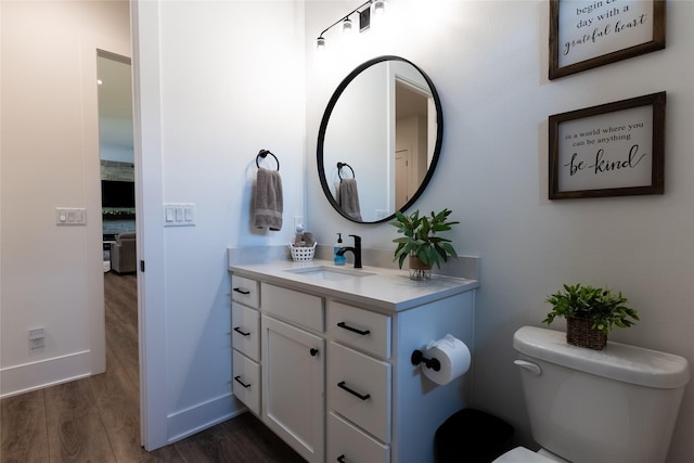 bathroom with vanity, hardwood / wood-style floors, and toilet