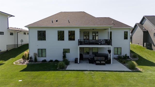 rear view of house featuring a balcony, an outdoor living space, a yard, and a patio