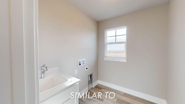 laundry area with hookup for an electric dryer, sink, washer hookup, and light hardwood / wood-style flooring