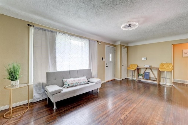 living room with dark hardwood / wood-style flooring and a textured ceiling