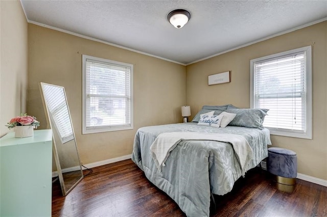 bedroom featuring dark hardwood / wood-style flooring, ornamental molding, and a textured ceiling