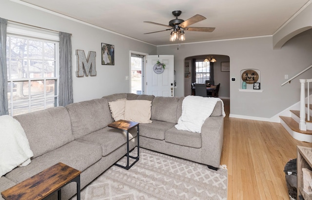 living room with hardwood / wood-style floors, ornamental molding, and ceiling fan