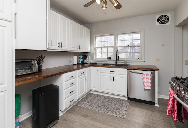 kitchen featuring wood counters, sink, white cabinets, and appliances with stainless steel finishes