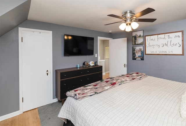 bedroom featuring hardwood / wood-style flooring, ceiling fan, and vaulted ceiling