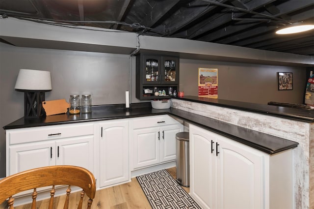 bar featuring white cabinetry and light hardwood / wood-style floors