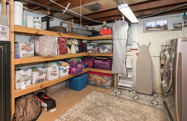 storage room featuring electric panel and washer / dryer