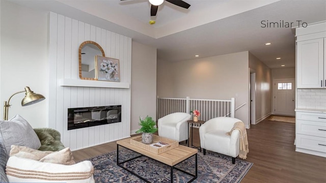 living room with a fireplace, dark hardwood / wood-style floors, and ceiling fan