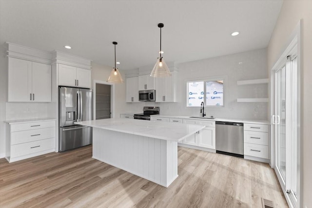 575 NW Prairie Rose Ln, Waukee, IA 50263 - kitchen featuring appliances with stainless steel finishes, a sink, white cabinets, light wood-type flooring, and recessed lighting