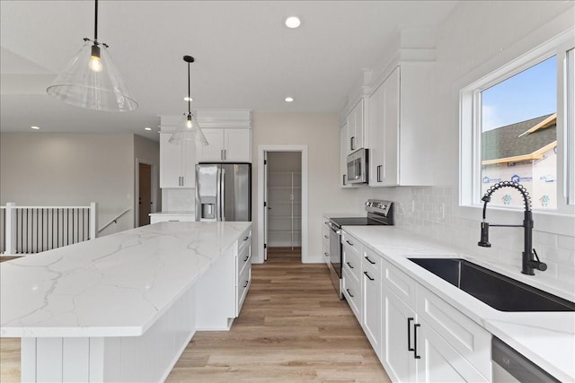 575 NW Prairie Rose Ln, Waukee, IA 50263 - kitchen featuring stainless steel appliances, a sink, a center island, light wood-style floors, and decorative backsplash