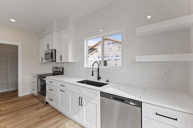 575 NW Prairie Rose Ln, Waukee, IA 50263 - kitchen with appliances with stainless steel finishes, a sink, white cabinets, backsplash, and recessed lighting