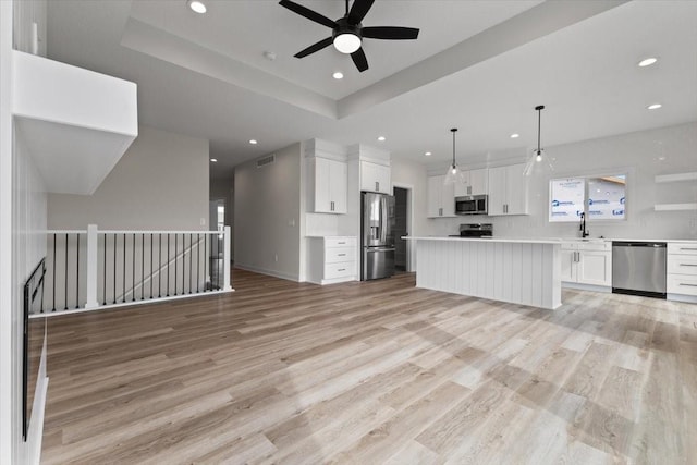 575 NW Prairie Rose Ln, Waukee, IA 50263 - kitchen with stainless steel appliances, open floor plan, ceiling fan, light wood finished floors, and recessed lighting