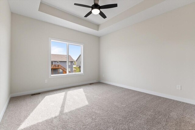 575 NW Prairie Rose Ln, Waukee, IA 50263 - carpeted spare room with baseboards, a ceiling fan, and a raised ceiling