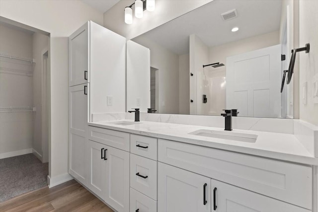 575 NW Prairie Rose Ln, Waukee, IA 50263 - full bath with a walk in shower, a spacious closet, baseboards, double vanity, and wood finished floors