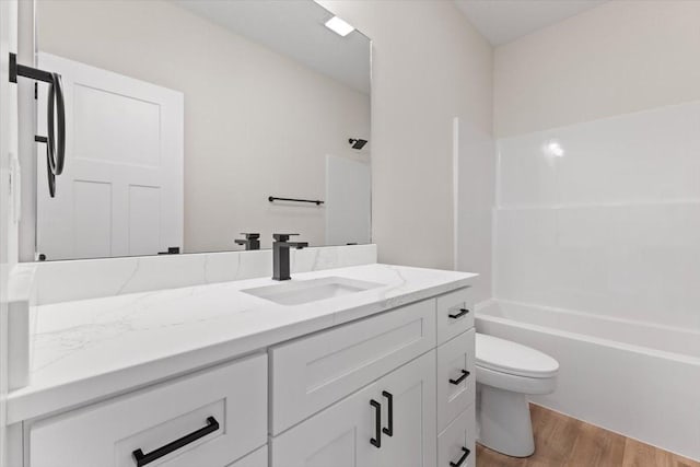 575 NW Prairie Rose Ln, Waukee, IA 50263 - bathroom featuring wood finished floors, toilet, vanity, and shower / washtub combination