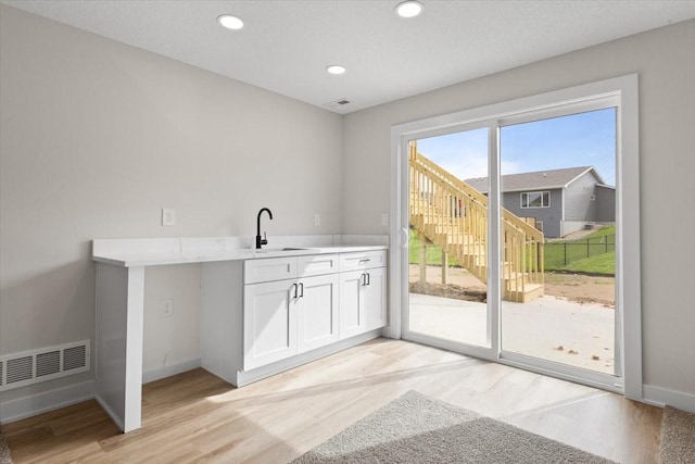 575 NW Prairie Rose Ln, Waukee, IA 50263 - washroom with a sink, light wood-type flooring, baseboards, and recessed lighting