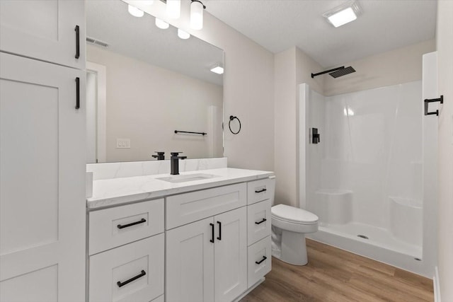575 NW Prairie Rose Ln, Waukee, IA 50263 - full bathroom with wood finished floors, a walk in shower, toilet, and vanity