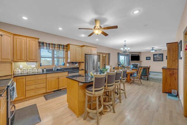 kitchen featuring pendant lighting, sink, a kitchen island, stainless steel appliances, and a kitchen bar