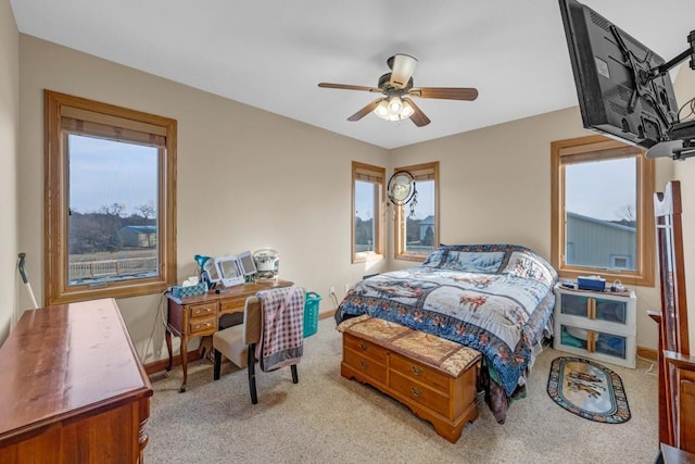 bedroom with multiple windows, light carpet, and ceiling fan