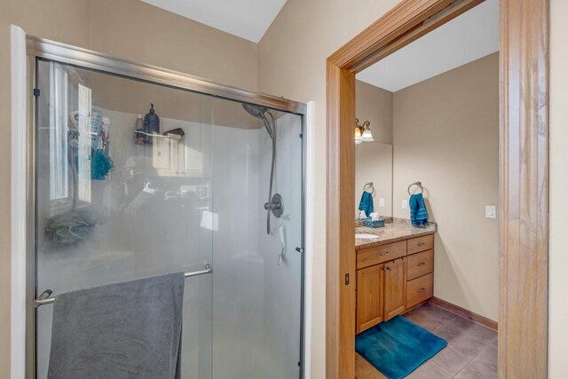 bathroom featuring vanity, tile patterned flooring, and a shower with door