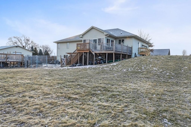 back of property featuring a wooden deck and a yard