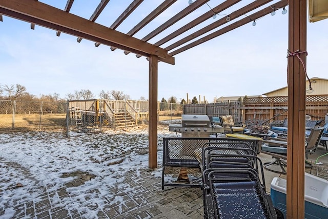 snow covered patio featuring area for grilling and a pergola