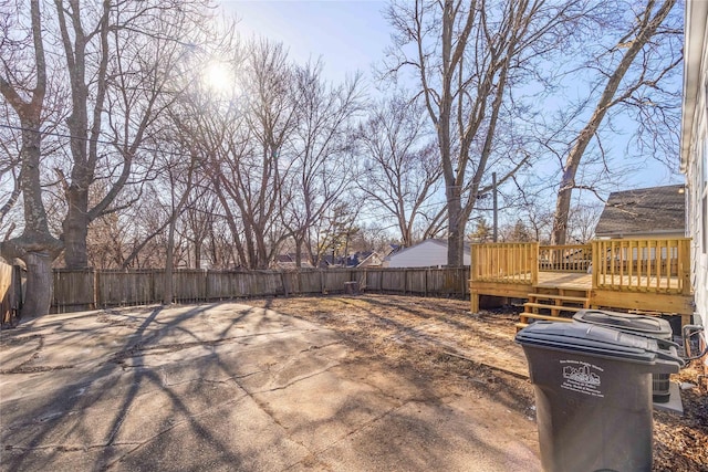 view of yard featuring a wooden deck and a patio