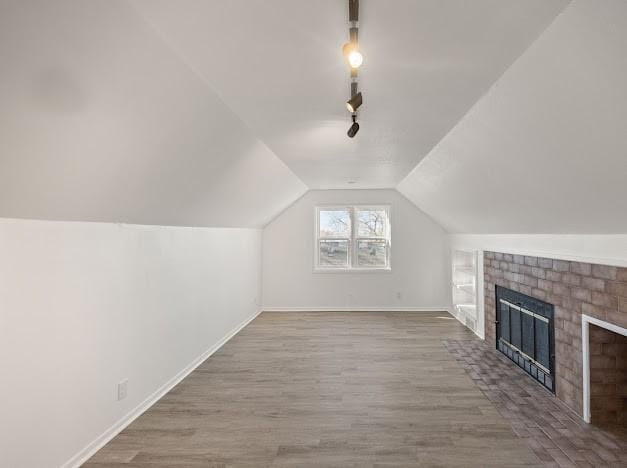 bonus room with lofted ceiling, a fireplace, and hardwood / wood-style floors