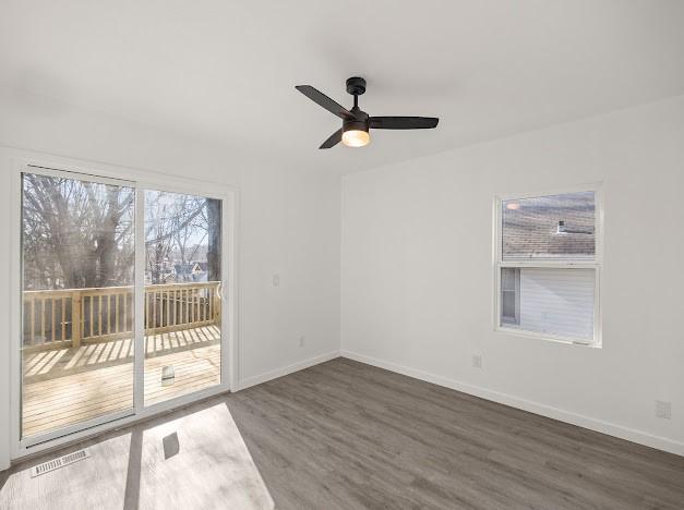 unfurnished room with dark wood-type flooring and ceiling fan