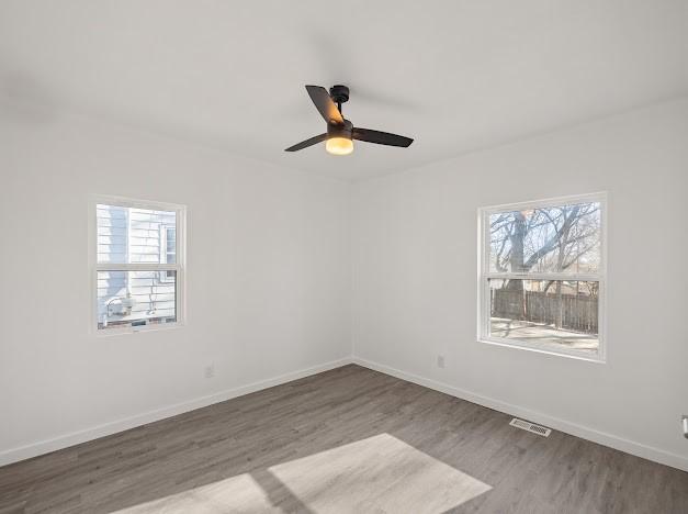 spare room featuring hardwood / wood-style flooring, plenty of natural light, and ceiling fan