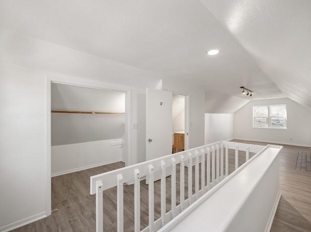 hallway with lofted ceiling and dark hardwood / wood-style flooring