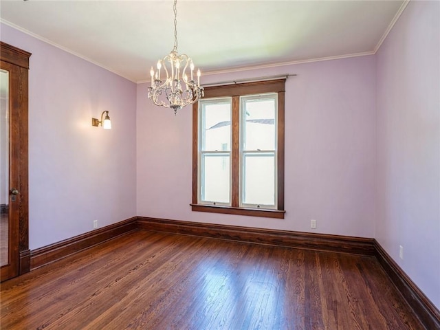 spare room with ornamental molding, dark hardwood / wood-style floors, and a chandelier