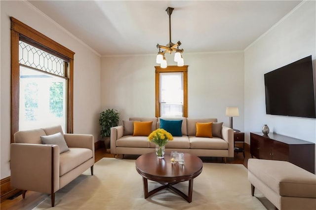 living room featuring crown molding, a notable chandelier, and light hardwood / wood-style floors