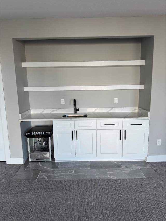 bar featuring sink and white cabinets