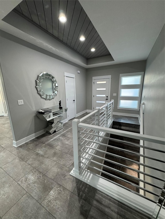 stairs with wood ceiling and a raised ceiling