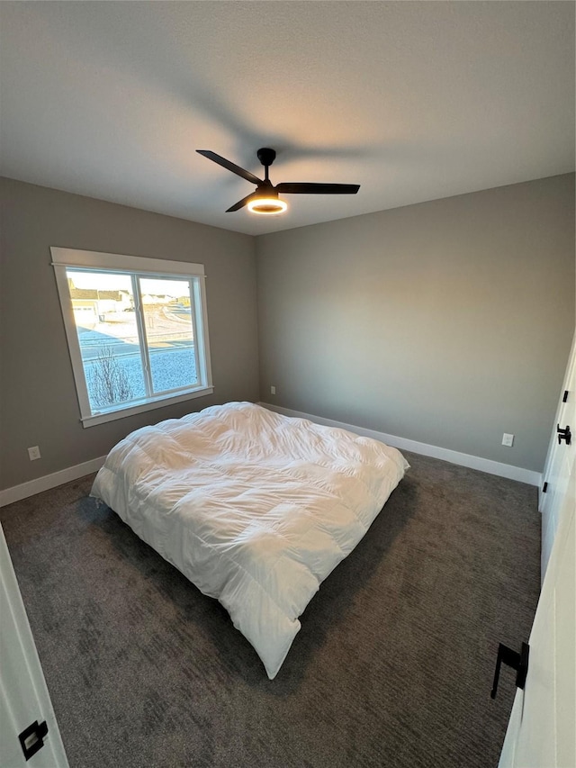 bedroom featuring ceiling fan and dark carpet