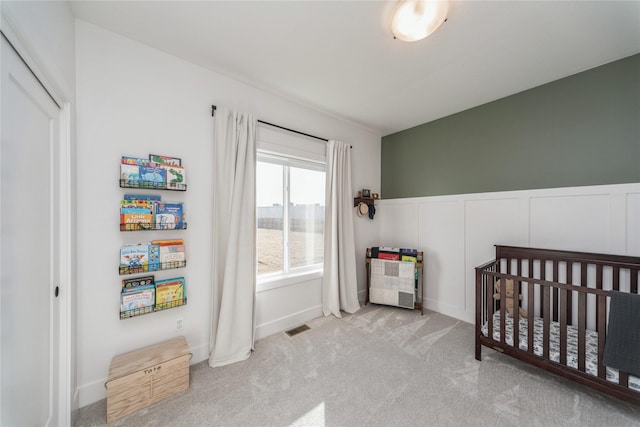 carpeted bedroom featuring a crib