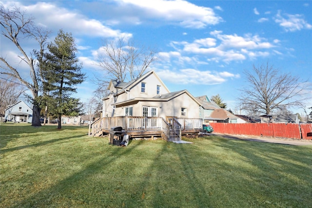 back of property with a deck and a lawn