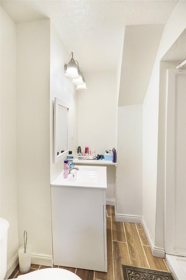 bathroom featuring vanity, toilet, and a textured ceiling