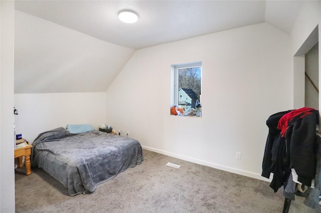 carpeted bedroom featuring lofted ceiling