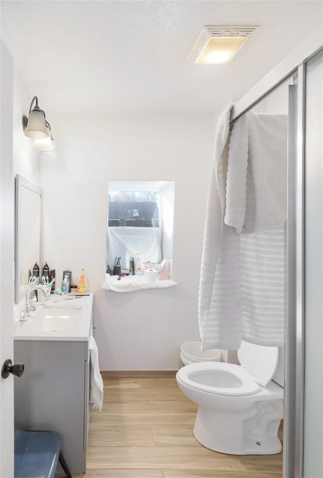 bathroom featuring vanity, hardwood / wood-style flooring, toilet, and a bidet