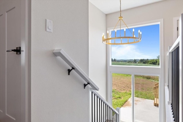 612 W Walnut Pl, Norwalk, IA 50211 - staircase featuring a chandelier and a textured wall