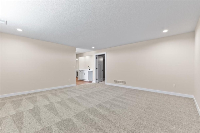612 W Walnut Pl, Norwalk, IA 50211 - spare room featuring light colored carpet, recessed lighting, and a textured ceiling
