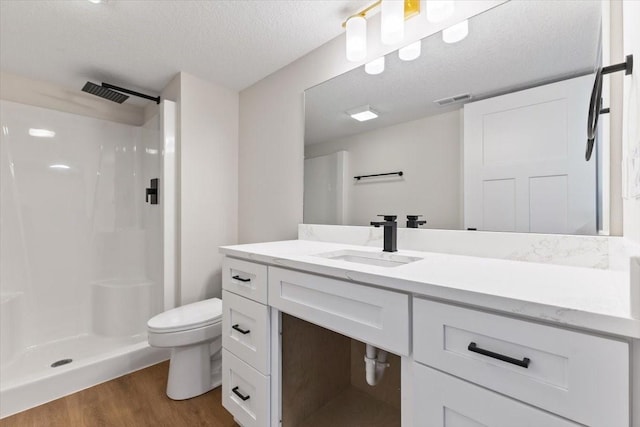 612 W Walnut Pl, Norwalk, IA 50211 - bathroom featuring walk in shower, wood finished floors, vanity, and a textured ceiling